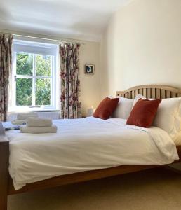 a bedroom with a large white bed with a window at Curragh-Ard Cottage in Newcastle