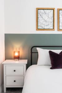 a bedroom with a bed and a nightstand with a lamp at Ness Heights, Spacious City Centre Townhouse in Inverness