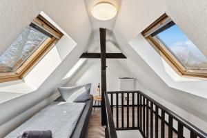 a small attic room with a bench and windows at Larooms - Naumi#1 in Merseburg