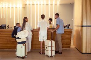 a group of people standing at a counter with luggage at Sonesta Maho Beach All Inclusive Resort Casino & Spa in Maho Reef