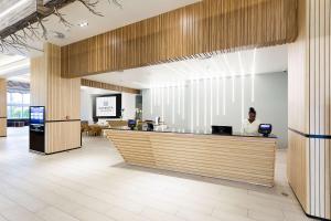 a man sitting at a counter in a lobby at Sonesta Maho Beach All Inclusive Resort Casino & Spa in Maho Reef