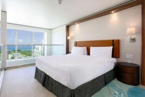 a bedroom with a large bed and a large window at Sonesta Maho Beach All Inclusive Resort Casino & Spa in Maho Reef
