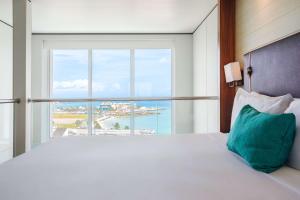 a bedroom with a bed with a large window at Sonesta Maho Beach All Inclusive Resort Casino & Spa in Maho Reef