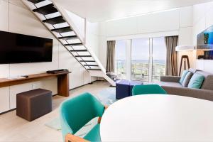 a living room with a tv and a staircase at Sonesta Maho Beach All Inclusive Resort Casino & Spa in Maho Reef