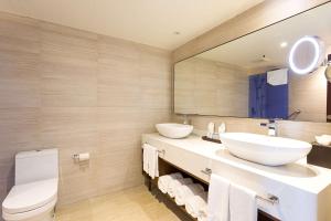 a bathroom with two sinks and a mirror at Sonesta Maho Beach All Inclusive Resort Casino & Spa in Maho Reef