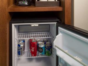an open refrigerator with sodas and cans of soda at Sonesta Maho Beach All Inclusive Resort Casino & Spa in Maho Reef