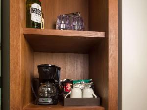 a cupboard with a coffee maker and glasses on it at Sonesta Maho Beach All Inclusive Resort Casino & Spa in Maho Reef