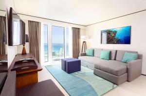 a living room with a couch and a large window at Sonesta Maho Beach All Inclusive Resort Casino & Spa in Maho Reef