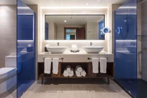 a bathroom with two sinks and a mirror at Sonesta Maho Beach All Inclusive Resort Casino & Spa in Maho Reef