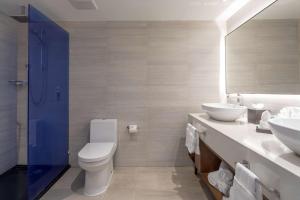 a bathroom with a toilet and a sink and a mirror at Sonesta Maho Beach All Inclusive Resort Casino & Spa in Maho Reef