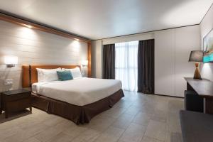 a hotel room with a bed and a desk at Sonesta Maho Beach All Inclusive Resort Casino & Spa in Maho Reef
