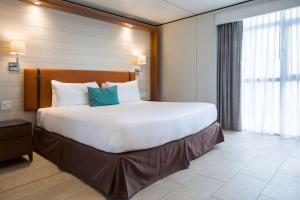 a large white bed in a hotel room at Sonesta Maho Beach All Inclusive Resort Casino & Spa in Maho Reef