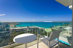 a white table and a chair on a balcony with the ocean at Sonesta Maho Beach All Inclusive Resort Casino & Spa in Maho Reef