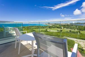 a balcony with a table and chairs and the ocean at Sonesta Maho Beach All Inclusive Resort Casino & Spa in Maho Reef