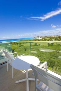 a white table and chairs on a balcony with the ocean at Sonesta Maho Beach All Inclusive Resort Casino & Spa in Maho Reef