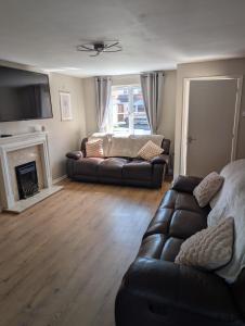 a living room with a couch and a fireplace at 3 bedroom detached by the sea in Prestatyn