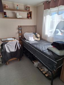 Una pequeña habitación con una cama y una ventana. en MOBIL HOME le CHOW-CHOW, en Valras-Plage