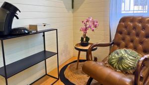 a room with a leather chair and a table with a plant at Pitchoune - Centre -Wifi - Equipé in Dax