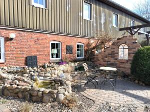 a brick building with a table and chairs in a yard at Hilde - gemütliche und moderne FeWo bei der Porzellanbörse in Handewitt