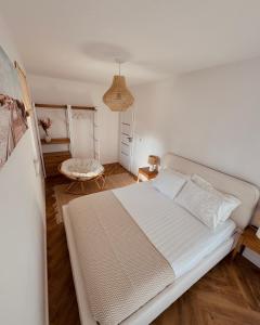 a bedroom with a white bed and a table at Apartamenty Cisza Natury - BRYZA in Augustów