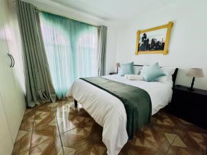 a bedroom with a large bed and a large window at Palm Haven 5 min drive to Carlswald Centre in Midrand