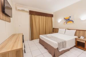 a hotel room with a bed and a tv at Hotel Nacional Inn Araçatuba in Araçatuba