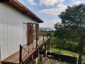 eine Holzterrasse an der Seite eines Hauses in der Unterkunft Družina Embalse Calamuchita in Embalse