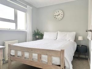 a bedroom with a bed with a clock on the wall at Falmouth Oasis with sub-tropical garden & parking in Falmouth