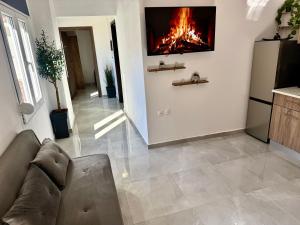 a living room with a couch and a fire on the wall at Το ΦΑΡΑΓΓΙ ΤΟΥ ΠΑΡΝΑΣΣΟΥ 4 in Velítsa