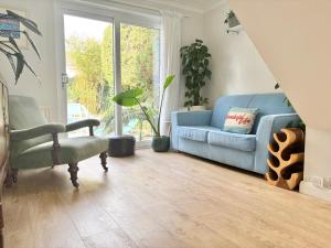 a living room with a blue couch and a chair at Falmouth Oasis with sub-tropical garden & parking in Falmouth +18 photos