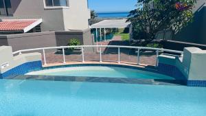 a swimming pool with a bridge over the water at Dolphin Beach Penthouse in Cape Town