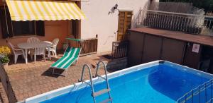 a blue swimming pool with a table and a patio at Casa PO LAZISE in Lazise