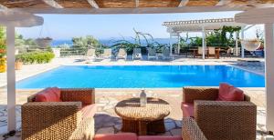 シヴォタにあるVilla Armoniaのプールサイドのテーブルと椅子付きのスイミングプール