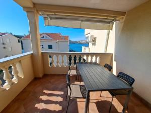 a table and chairs on a balcony with a view of the ocean at Apartment Solis 8 in Stara Novalja