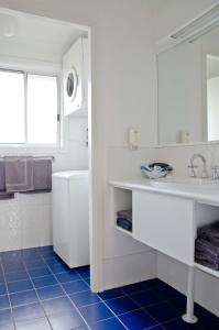 a white bathroom with a sink and a tub at Baybrook Motor Inn in Muswellbrook