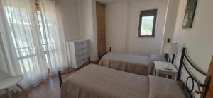 a bedroom with two beds and a dresser and a window at Finestra sul porto in Marina di Camerota +12 photos