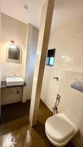 a bathroom with a toilet and a sink at Hotel Dwani Palace in Navi Mumbai