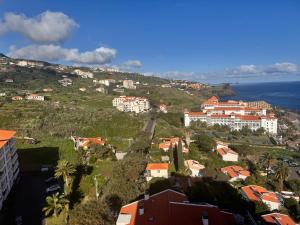 a town on a hill with houses and the ocean at Aylevarroo Penthouse in Caniço