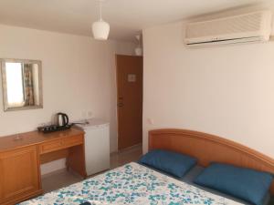 a bedroom with a bed and a desk and a telephone at Özmert otel in Antalya