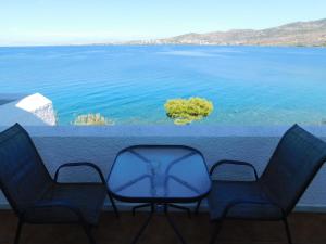 two chairs and a table with a view of the water at Perdika Mare Guesthouse in Perdika