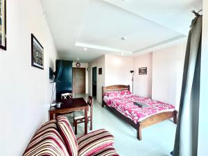 une chambre avec un lit et un bureau dans l'établissement Beach 7 Condo Pattaya 11, à Jomtien Beach 4 autres photos