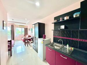 une cuisine avec un évier et un réfrigérateur dans l'établissement Beach 7 Condo Pattaya 11, à Jomtien Beach