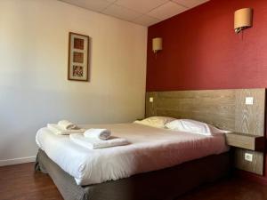 a bedroom with a bed with towels on it at Hôtel Le Boïate in Arès