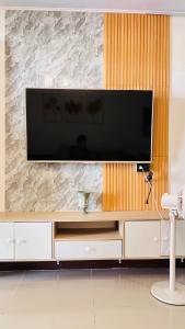 a large entertainment center with a flat screen tv on a wall at Orilla Transient 1 in Mabalacat