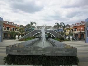 a fountain in a courtyard with a bridge at Orilla Transient 1 in Mabalacat