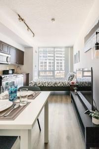 a kitchen and a living room with a table at CN Tower Luxe Suites - Prime Downtown Location in Toronto
