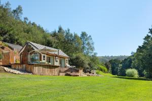 a house on a hill with a grass field at Amazing Riverside Retreat with Hot Tub & EcoPool in Mossel Bay