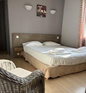 a bedroom with two beds and a chair and a bed at Hôtel Le Boïate in Arès