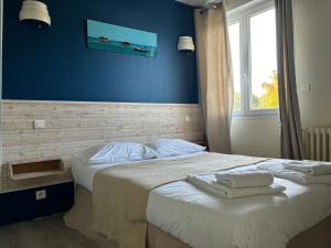 a bedroom with a bed with two towels on it at Hôtel Le Boïate in Arès