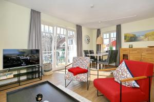 a living room with a red couch and a tv at Villa Seepferdchen Wohnung 08 in Kühlungsborn